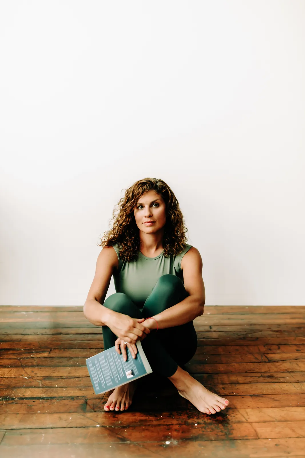 Rachel Krall sitting on the floor holding a book